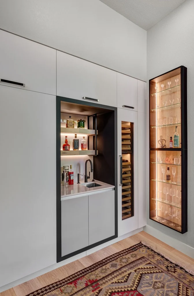 Blanc and Noir kitchen remodel featuring full-height matte white slab cabinetry with minimalist pulls and hidden appliance garages in Sacramento, CA by Tenax Construction