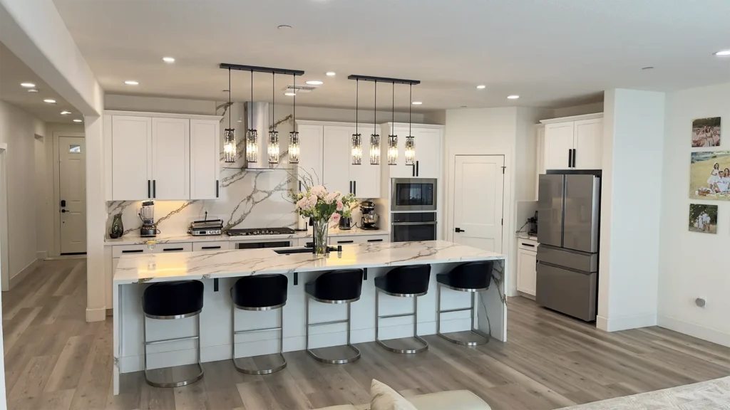 Modern luxury kitchen remodel featuring pendant chandeliers over kitchen island with updated lighting design in Roseville, CA by Tenax Construction