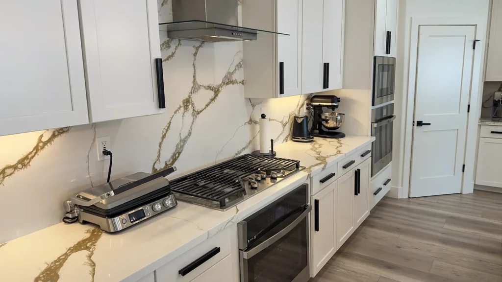 Modern luxury kitchen remodel featuring wide plank light-toned flooring for warmth and continuity in Roseville, CA by Tenax Construction