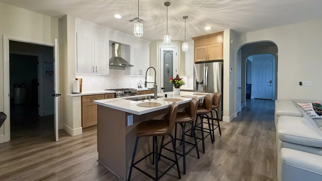 Full kitchen remodel featuring completed kitchen with island seating quartz countertops and herringbone backsplash in Elk Grove, CA by Tenax Construction