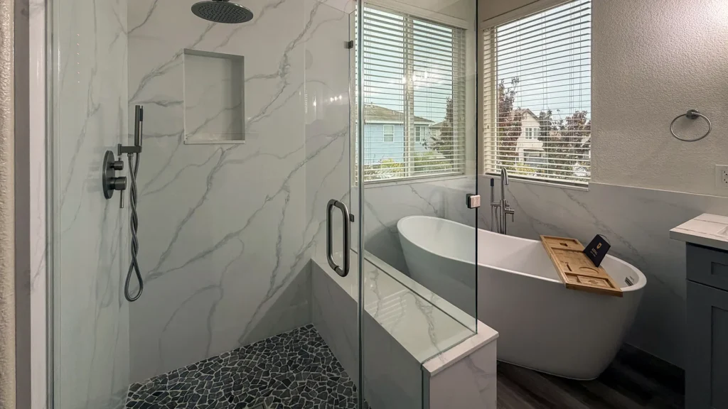 Spa-like master bathroom remodel featuring enlarged walk-in shower with marble walls up to 90 inches and built-in bench in Elk Grove, CA by Tenax Construction