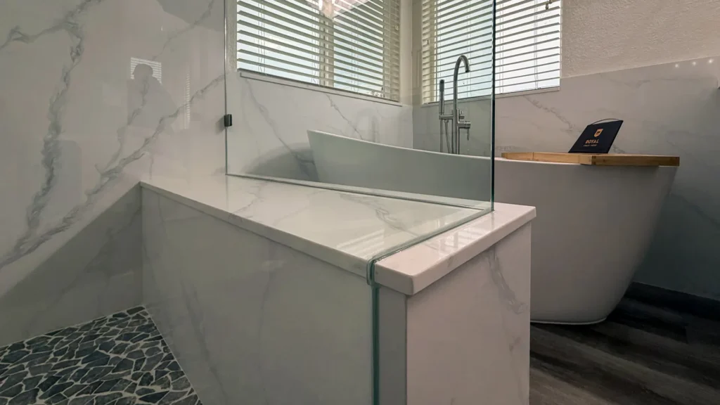 Spa-like master bathroom remodel featuring frameless glass shower enclosure highlighting marble walls and open airy feel in Elk Grove, CA by Tenax Construction