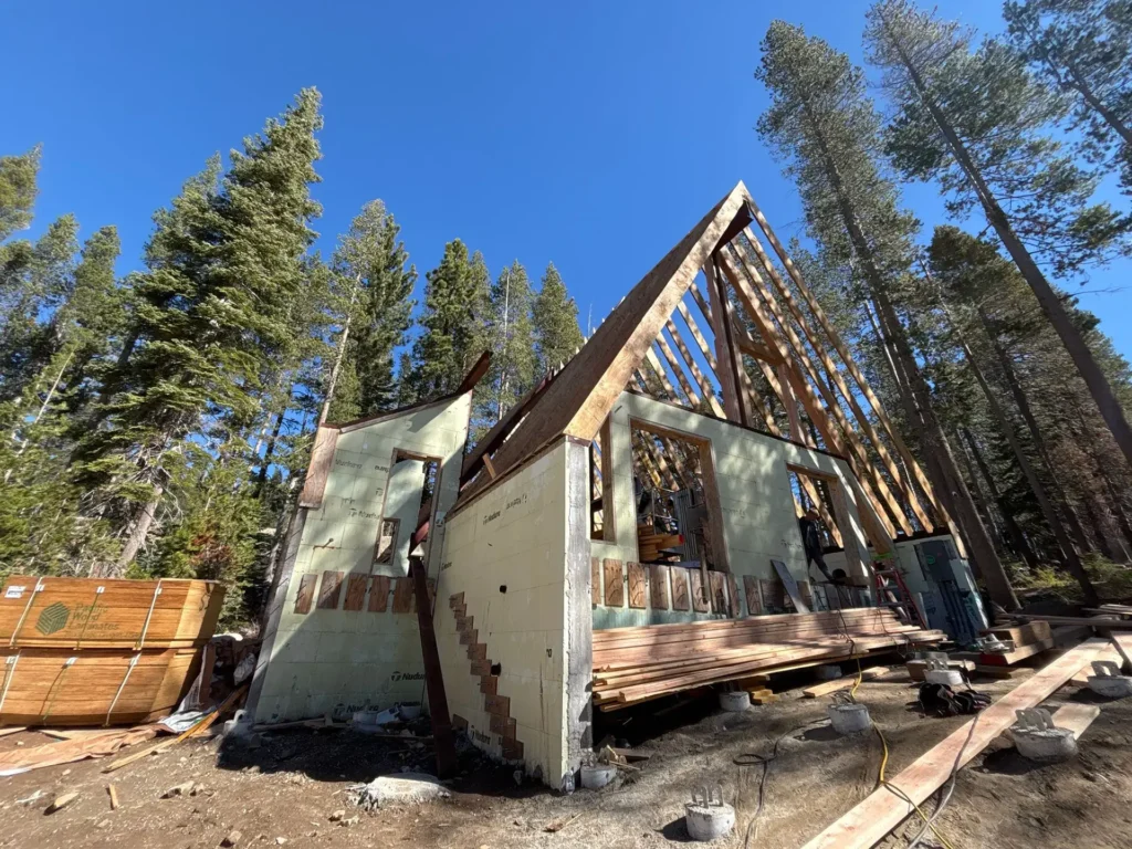 ICF mountain home construction featuring A-frame inspired design with towering glass gable wall in Soda Springs, CA by Tenax Construction