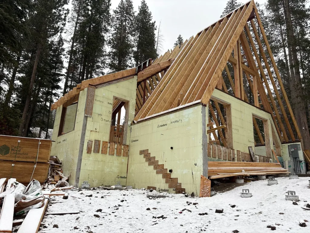 ICF mountain home construction featuring structural framing with rafters and architectural elements in Soda Springs, CA by Tenax Construction
