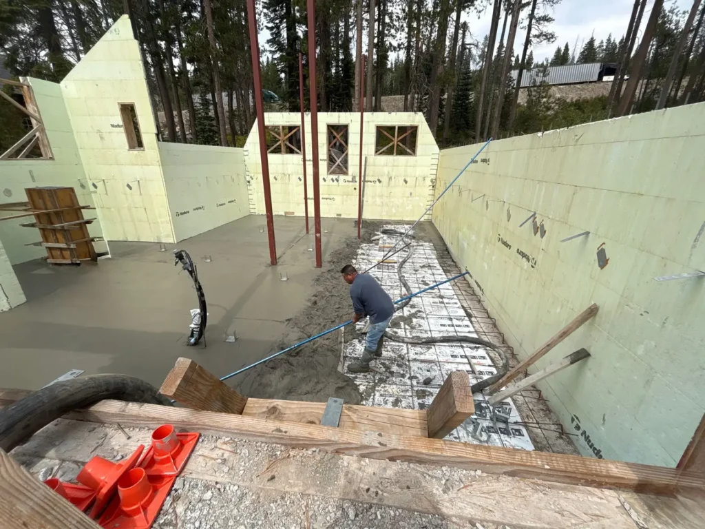 ICF mountain home construction featuring engineered steel beam installation for A-frame roof support in Soda Springs, CA by Tenax Construction