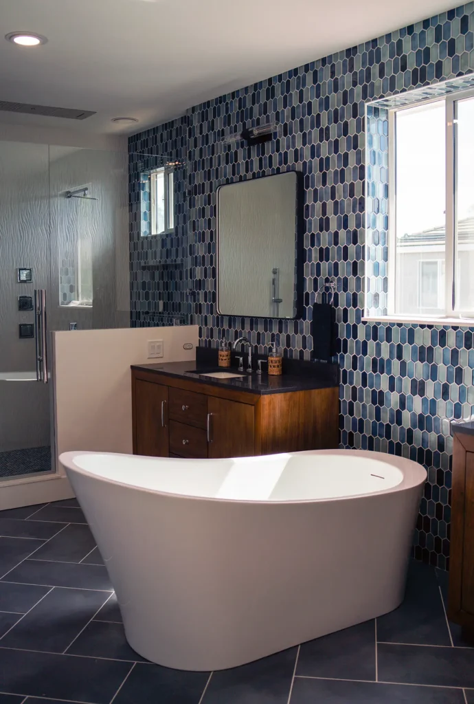 Full bathroom remodel featuring master bathroom tile feature wall and new vanity with mirror lights in Sacramento, CA by Tenax Construction